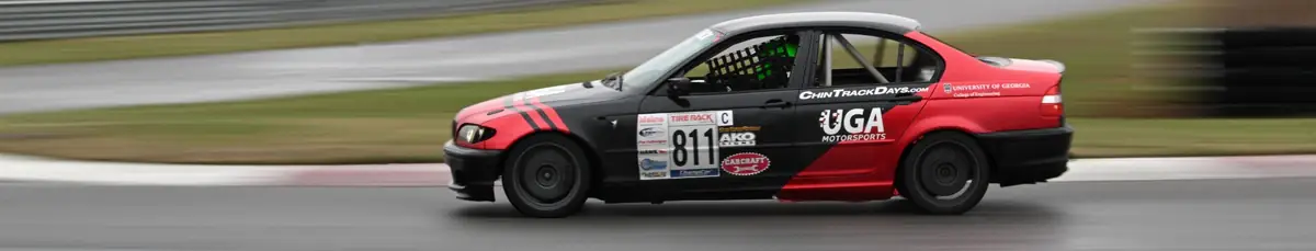 ChampCar BMW carving through a wet corner at speed