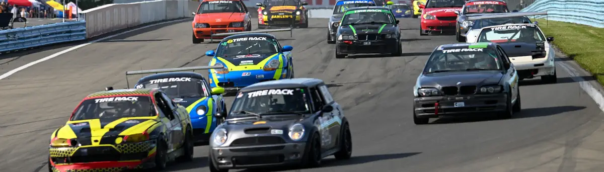 ChampCar field charging into Turn 1 at speed